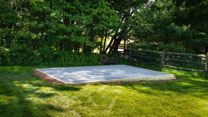 a nice gravel foundation by a fence for the article how to build a shed foundation on uneven ground