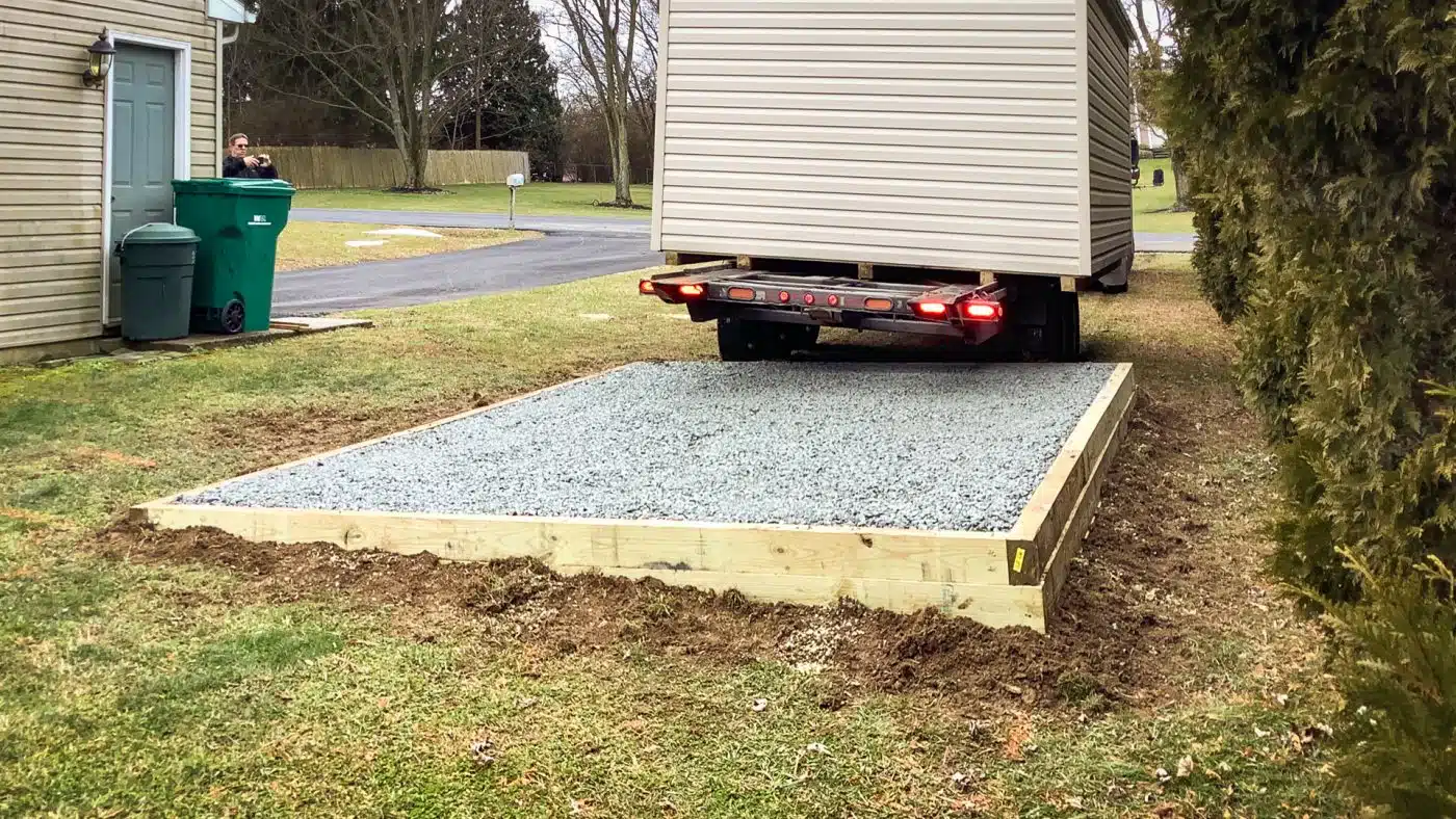 A shed foundation receiving delivery of a prefabricated shed