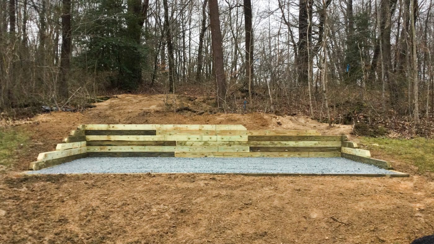 A shed foundation made from crushed stone and pressure-treated lumber