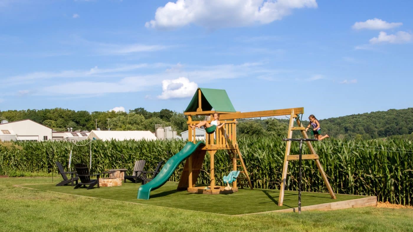 children playing on swingset after artificial grass installation