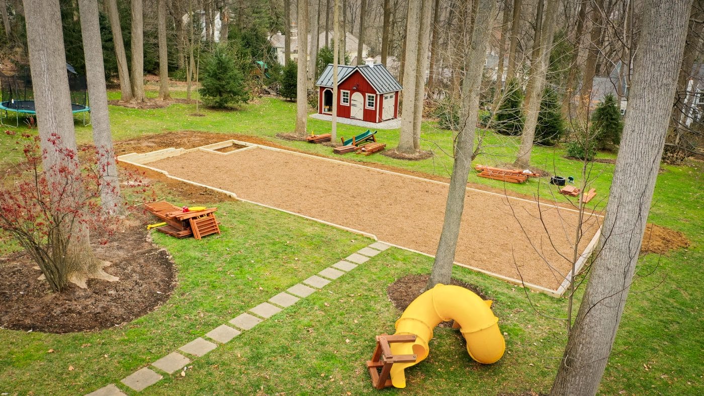 A swingset base built with wood chips and a crushed stone foundation