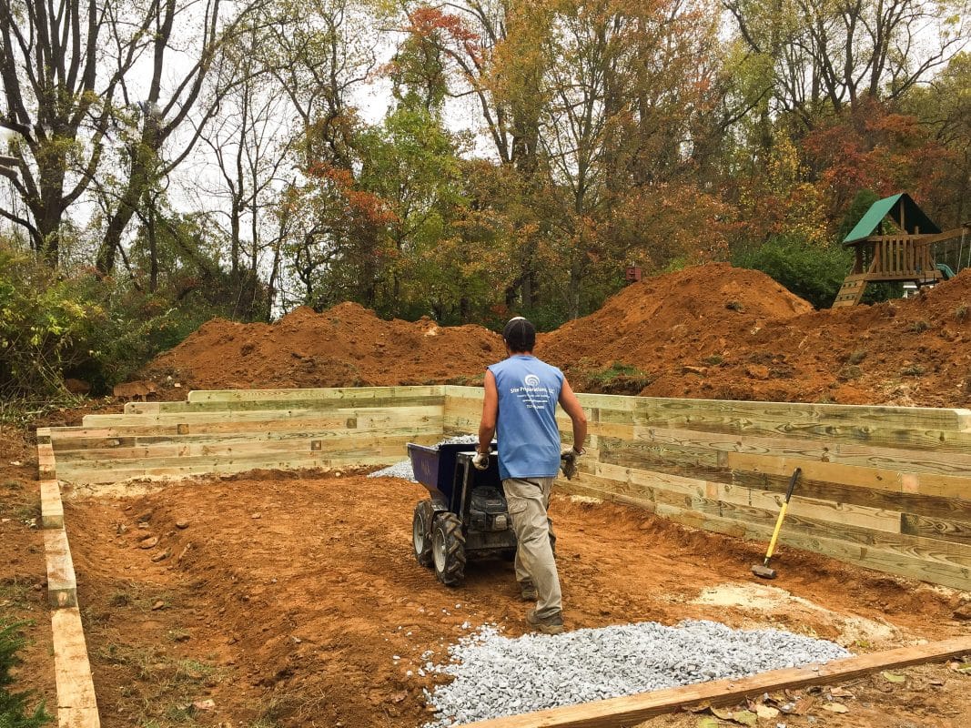 A site preparation contractor installing a gravel garage pad